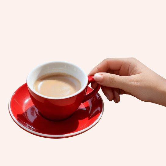 Cup of espresso with hand holding it