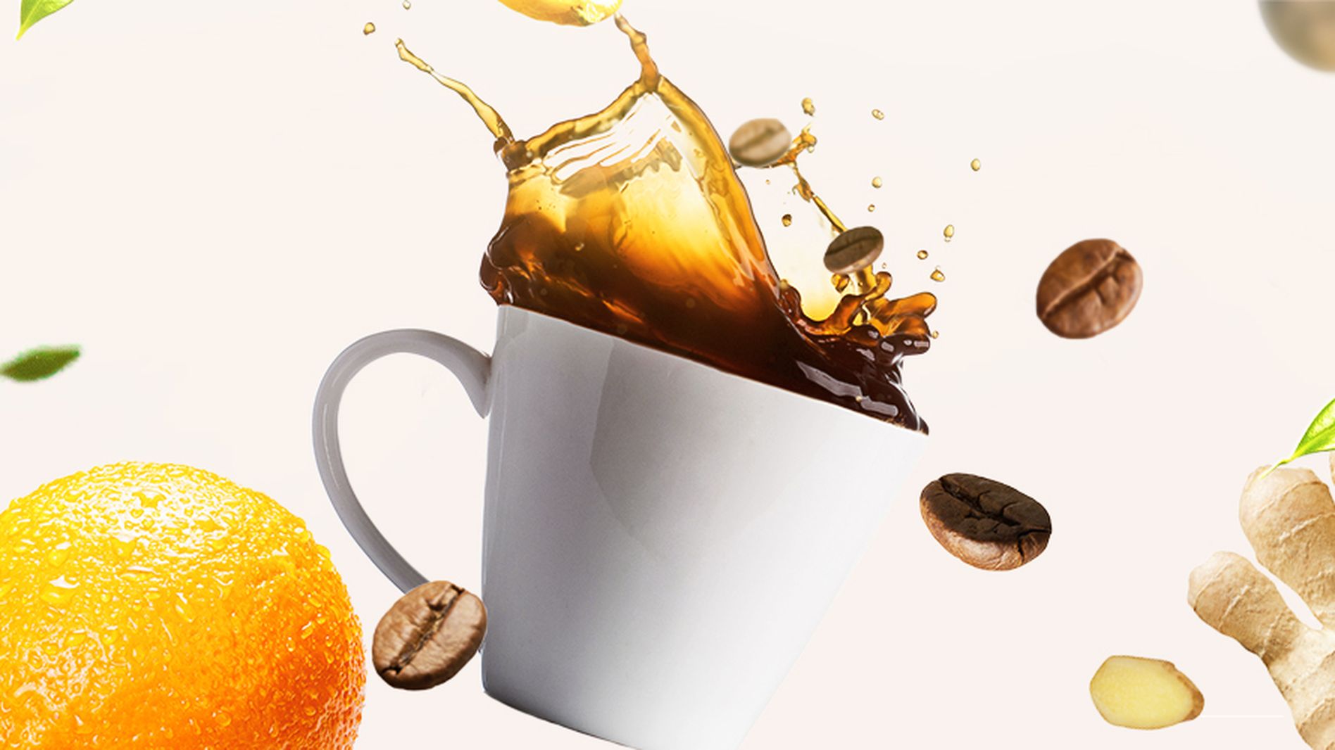 A white mug with splashing coffee surrounded by floating ginger, orange, lemon, coffee beans, and green leaves on a light background.